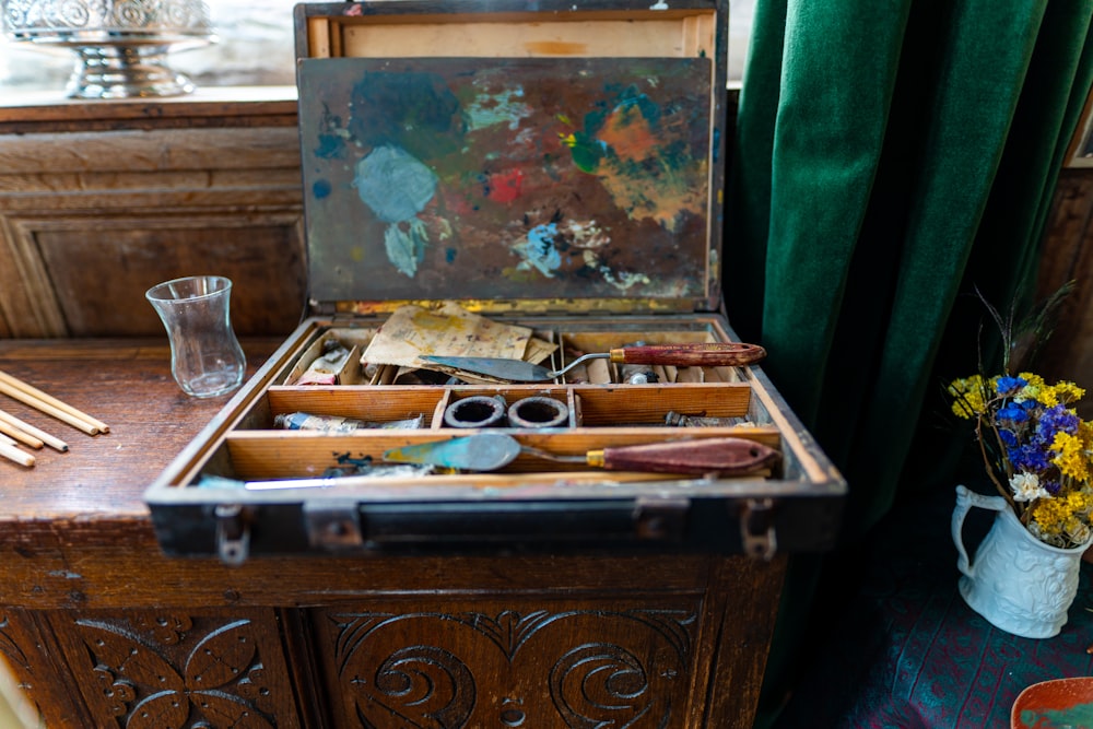 brown wooden chest with brass and silver tools