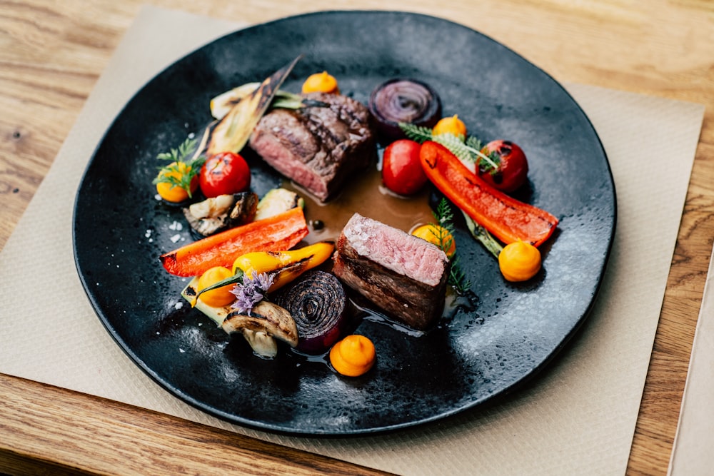 Carne cocida con verduras en plato redondo negro