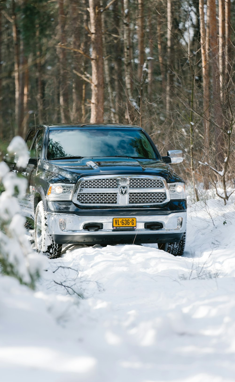 Coche Chevrolet negro en suelo cubierto de nieve durante el día