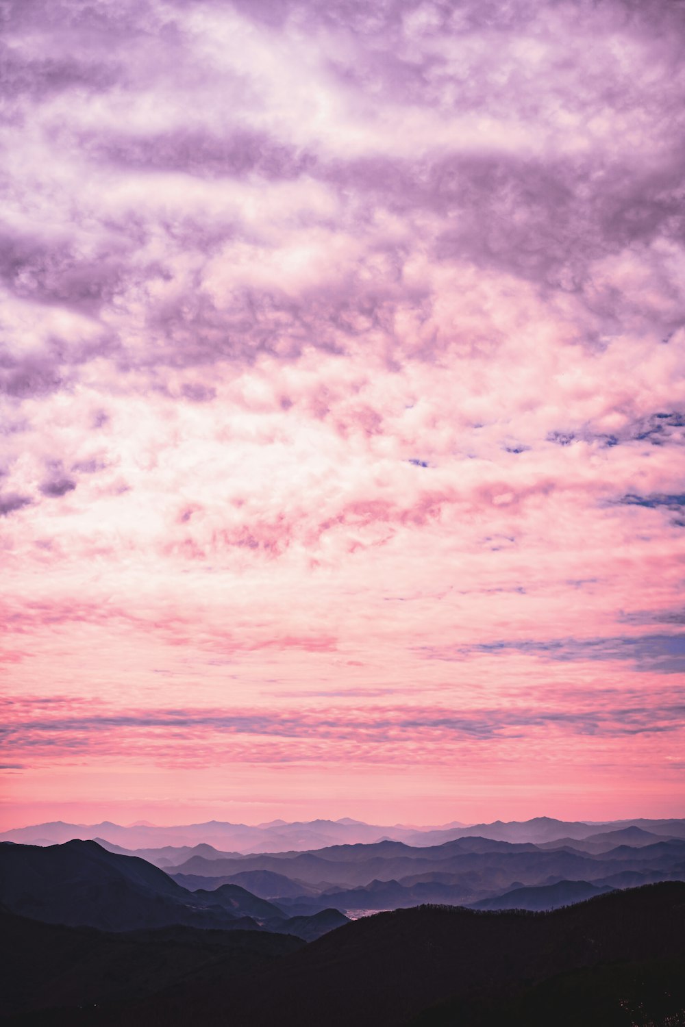 silhouette of mountains under cloudy sky during daytime