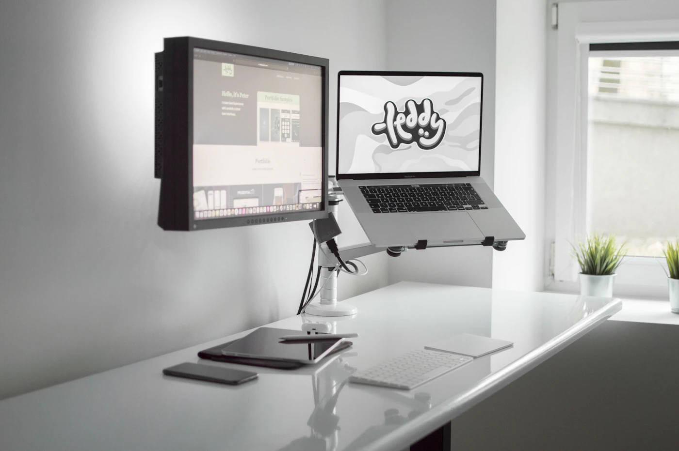 Person standing at a home office desk in front of a computer monitor