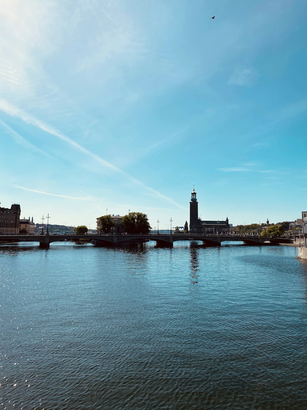 body of water near building under blue sky during daytime