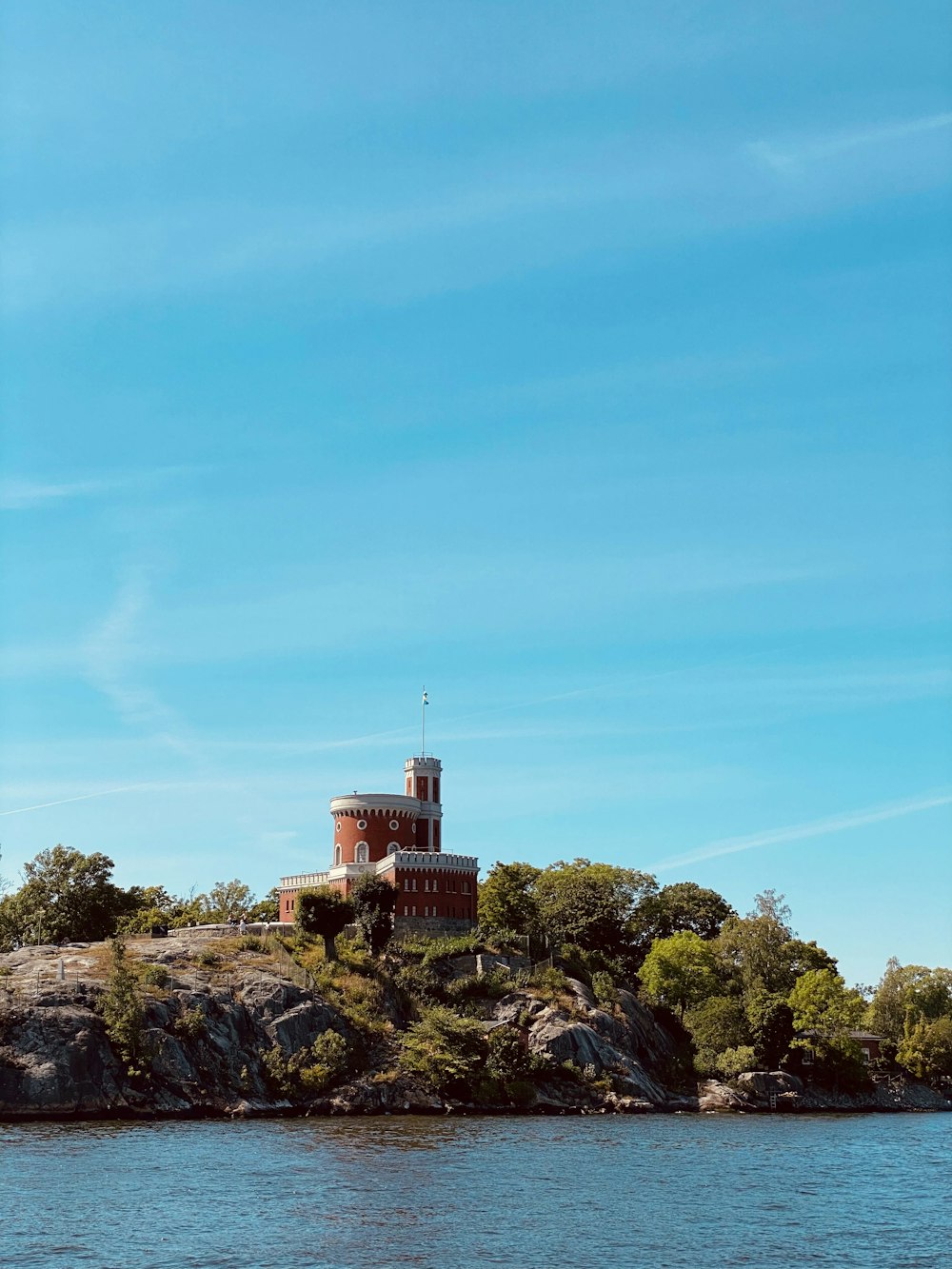 brown concrete building on top of hill under blue sky during daytime