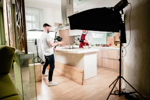 Photographer capturing styled food shots in a bright studio with natural light and minimalist decor.