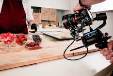 black dslr camera on brown wooden chopping board
