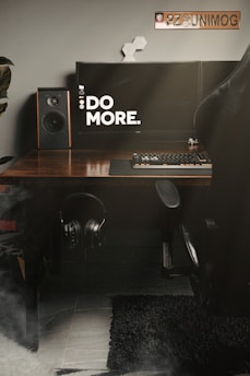 black and silver speaker on brown wooden desk