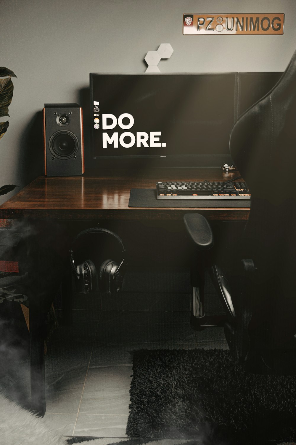 black and silver speaker on brown wooden desk