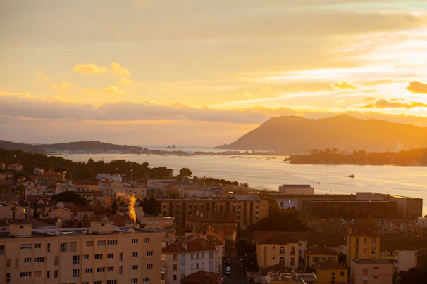 Sunset casting warm terracotta hues over a quiet coastal village landscape.