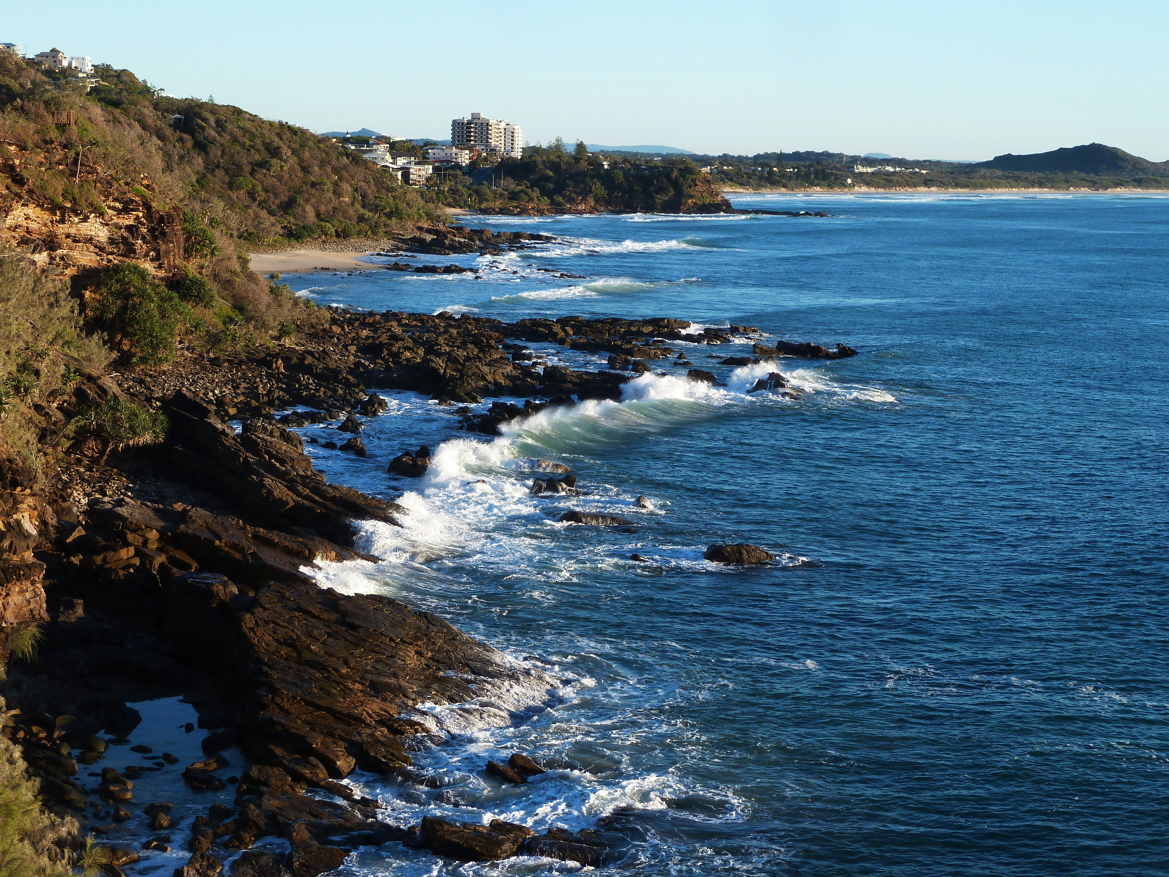 aerial view of sea waves crashing on shore during daytime