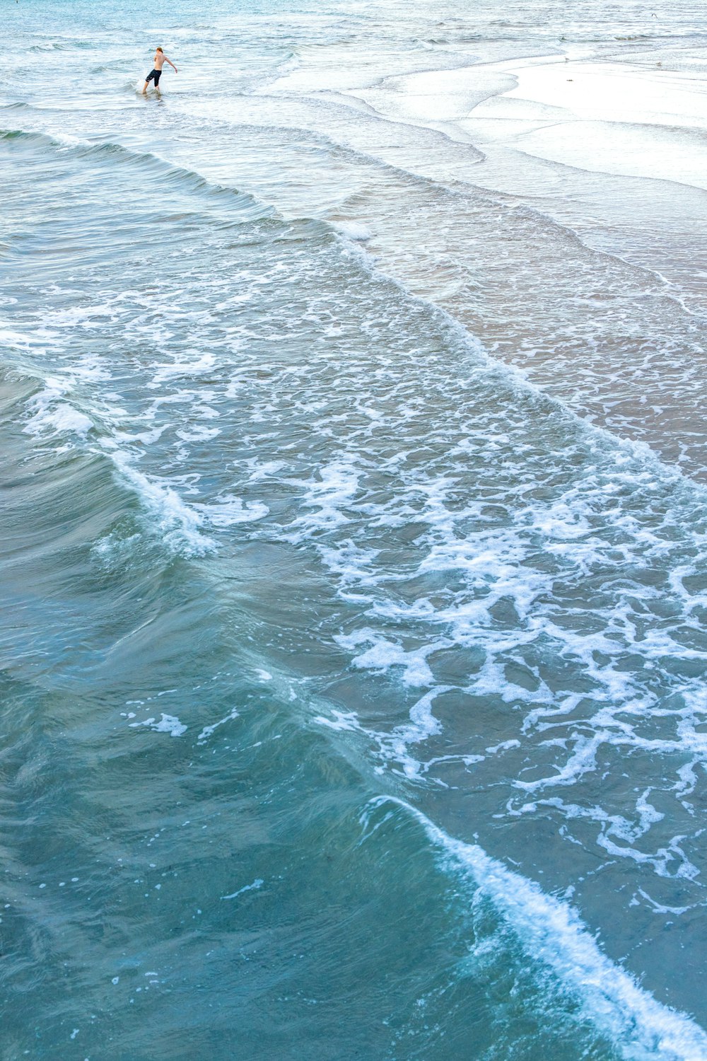corpo de água perto da areia cinzenta durante o dia