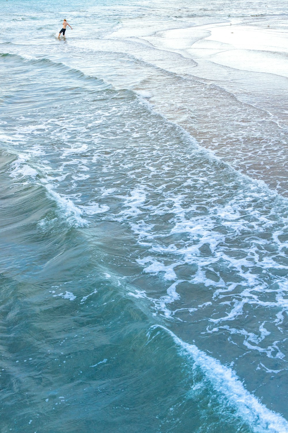 Cuerpo de agua cerca de arena gris durante el día