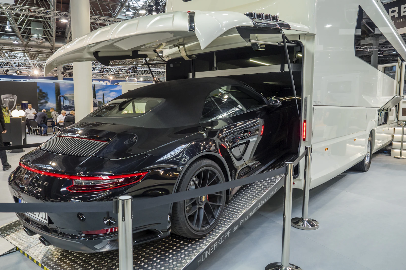 Black Porsche 911 Cabriolet being loaded into an enclosed car transporter