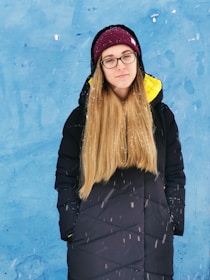 A woman with cool ash blonde hair styled in a cozy winter look.