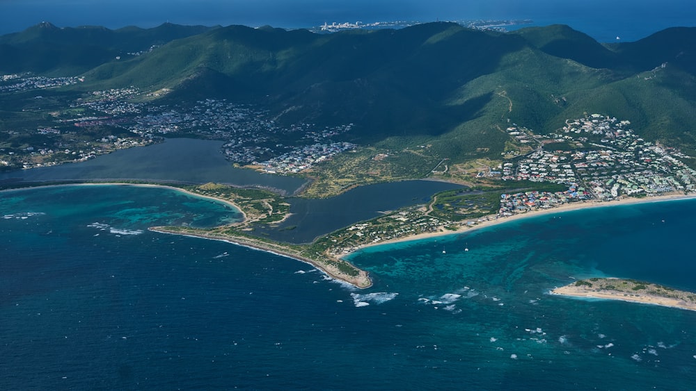 aerial view of green and brown mountains beside blue sea during daytime