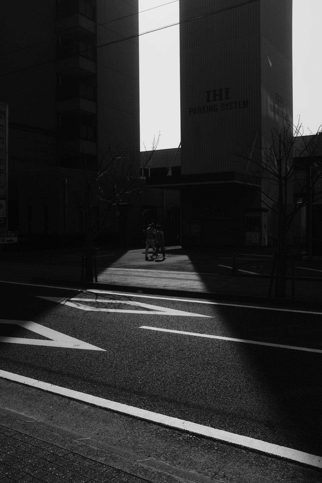 grayscale photo of man riding bicycle on road