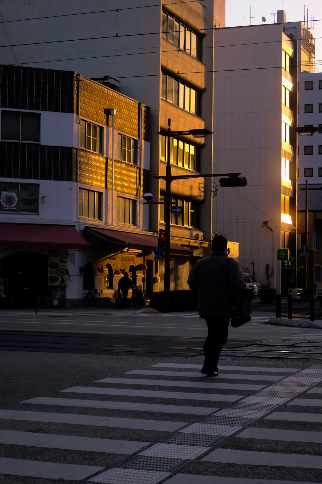 man in black jacket walking on sidewalk during daytime