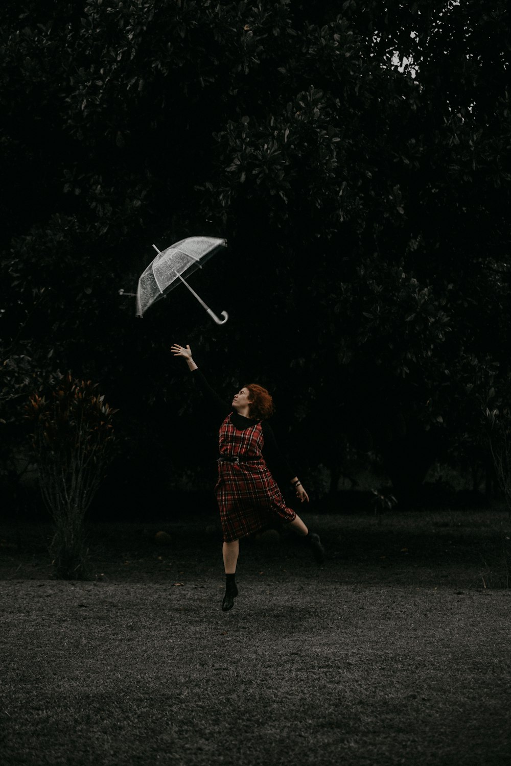 woman in red and black plaid dress shirt holding umbrella