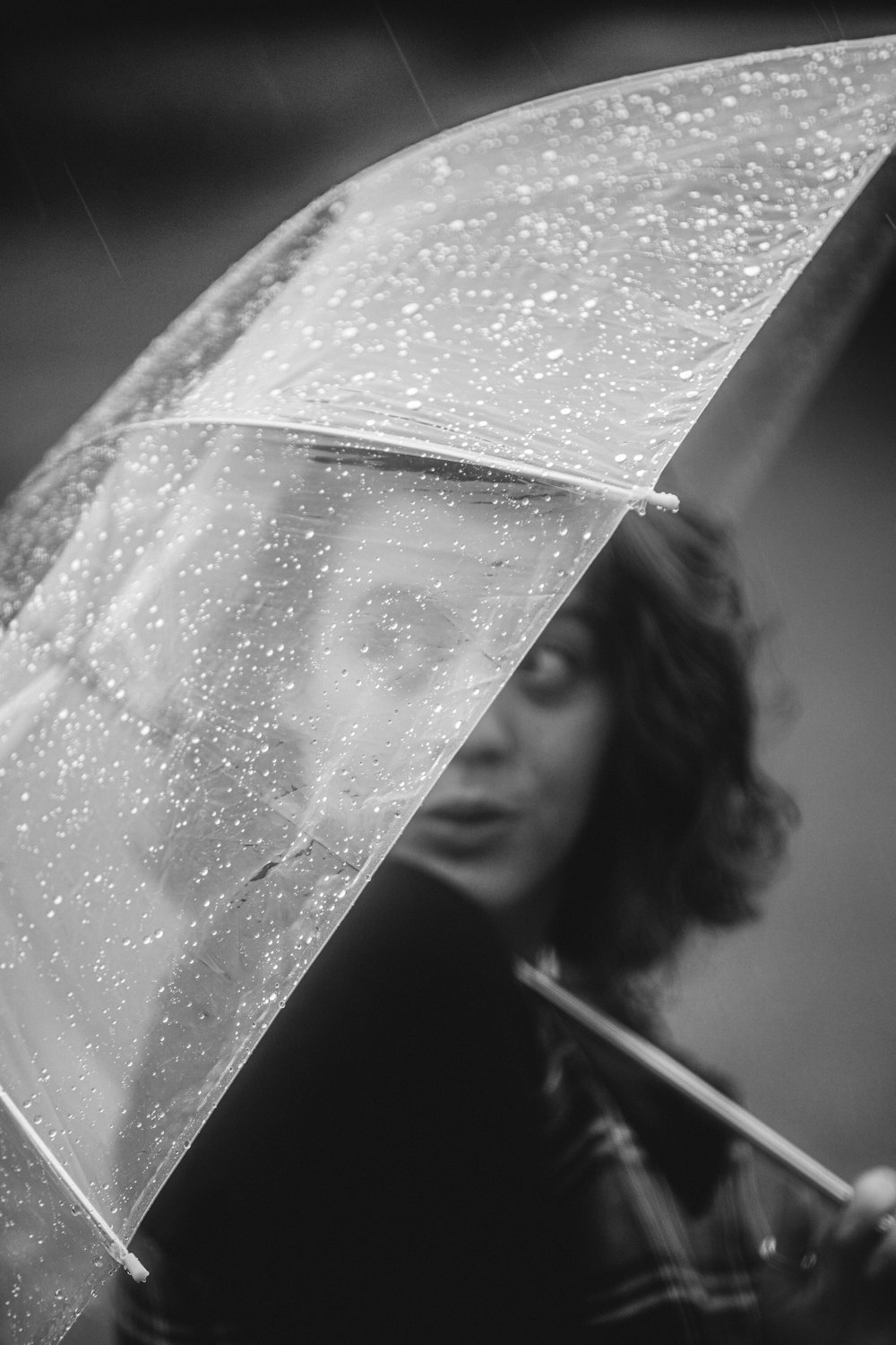 grayscale photo of woman covering her face with white textile