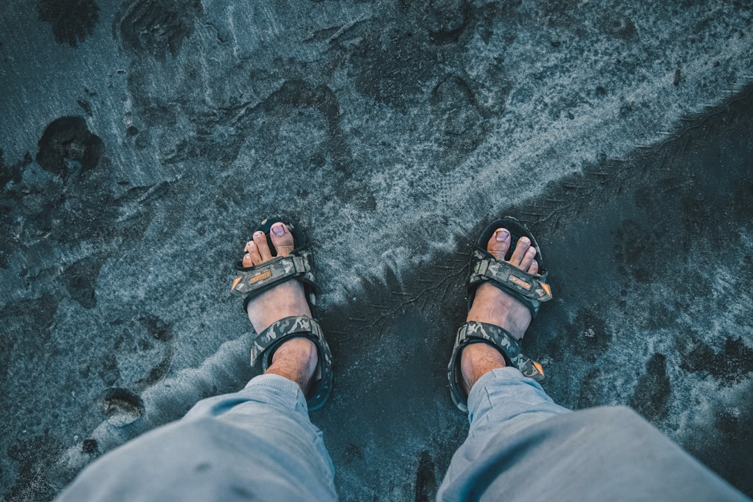 person in grey pants wearing black hiking sandals