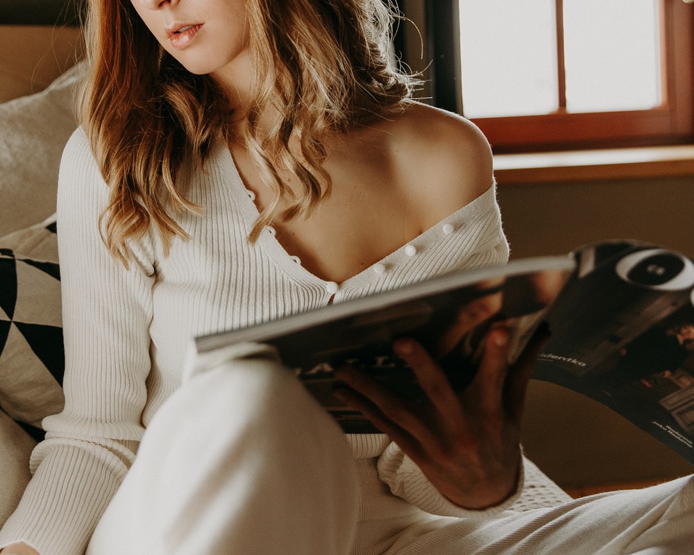 woman in white long sleeve shirt reading book