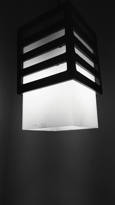 Close-up of a modern light fixture casting precise beams of light in a minimalist room.