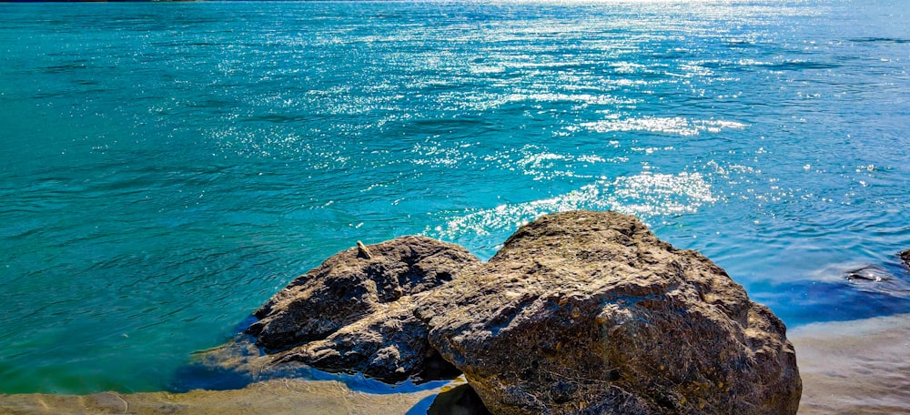 brown rock formation beside body of water during daytime