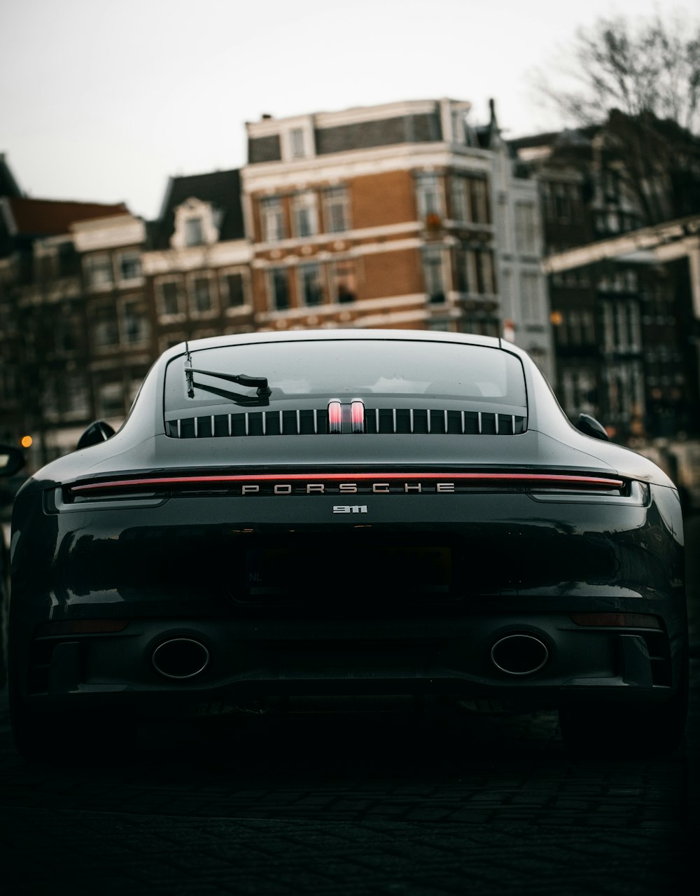 Porsche 911 noire garée dans la rue pendant la journée