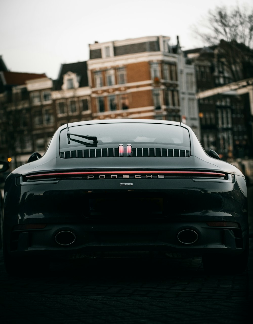 Porsche 911 nera parcheggiata in strada durante il giorno