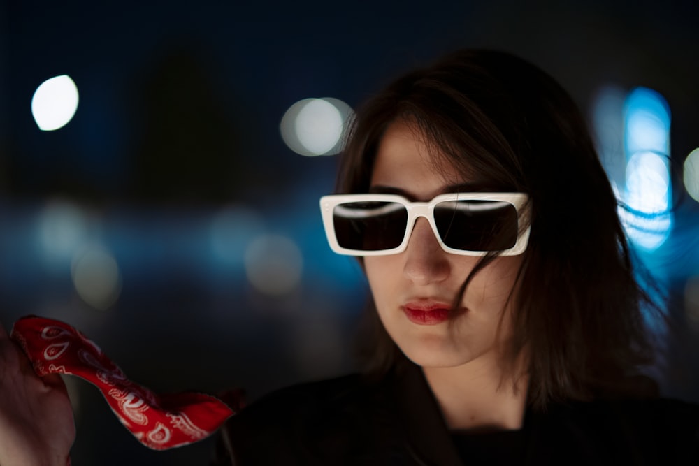 woman in black jacket wearing white framed sunglasses