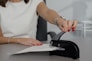 woman in white shirt holding pen writing on white paper