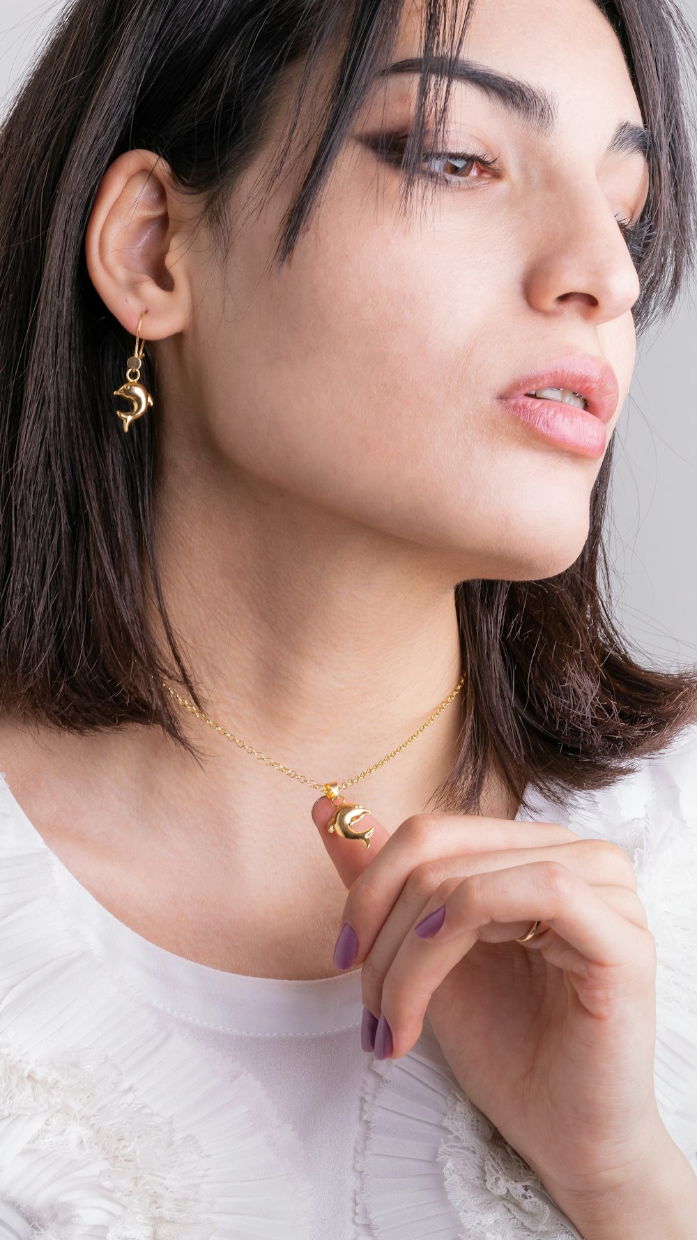 woman in white shirt wearing gold necklace