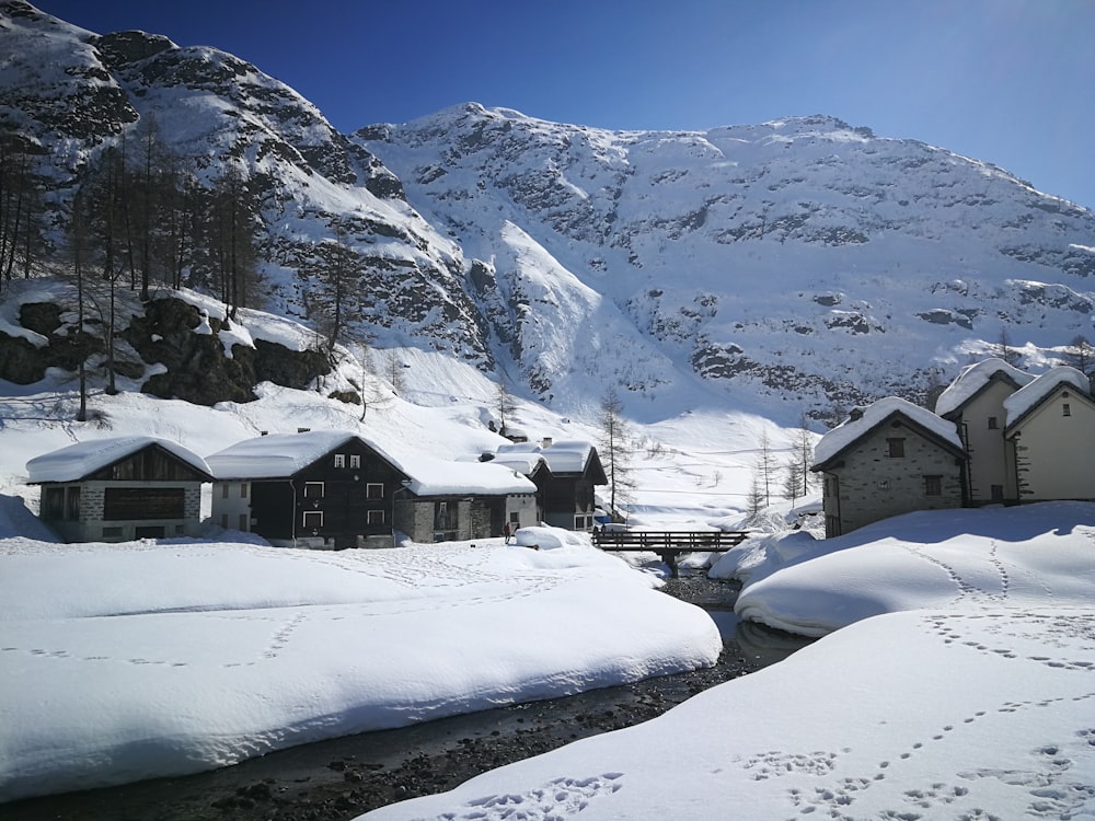 Maison enneigée près de la montagne pendant la journée