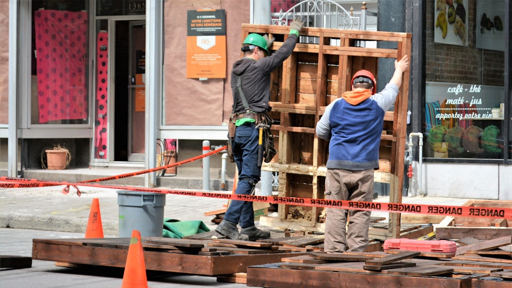 Mann in blauer Jacke und blauer Jeans mit orange-weißem Surfbrett