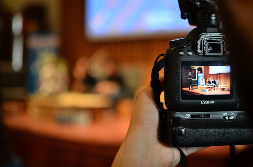 person holding black dslr camera