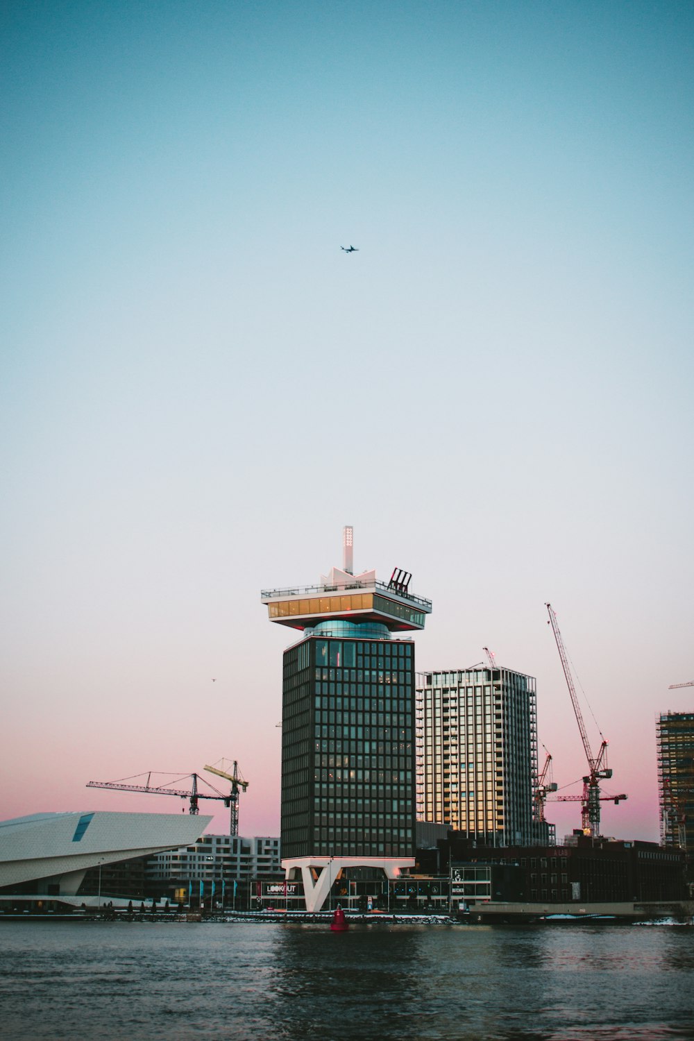 white airplane flying over the city during daytime