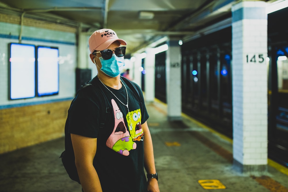 woman in black crew neck t-shirt wearing white cap and sunglasses