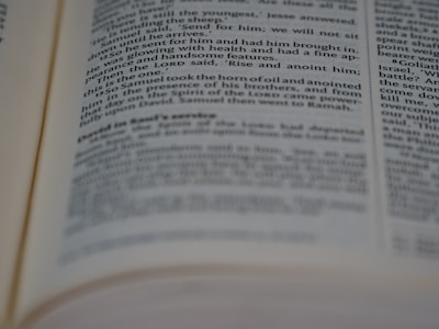 A close-up view of an open book showing printed text in English. The text is in two columns, with portions of it slightly out of focus due to the depth of field.