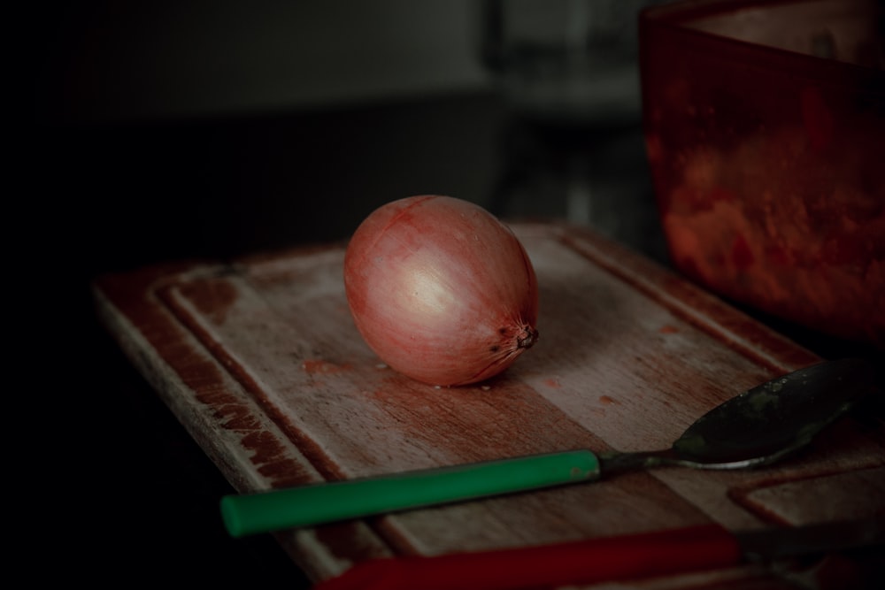 red apple fruit on brown wooden chopping board