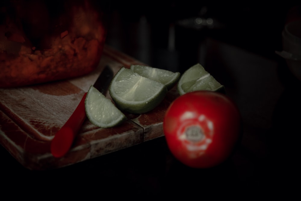 red tomato on brown wooden chopping board