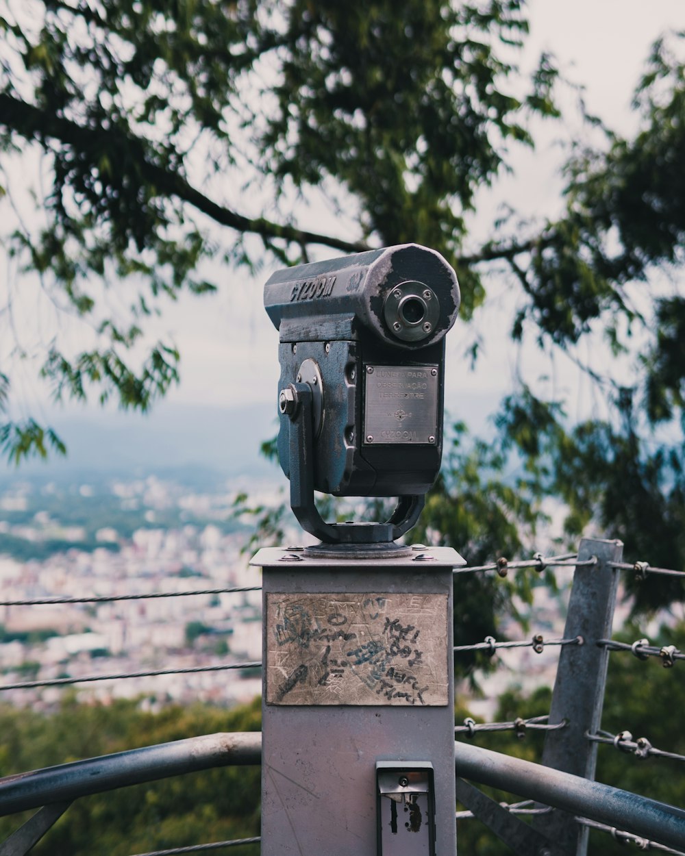 black and gray camera on brown wooden fence during daytime