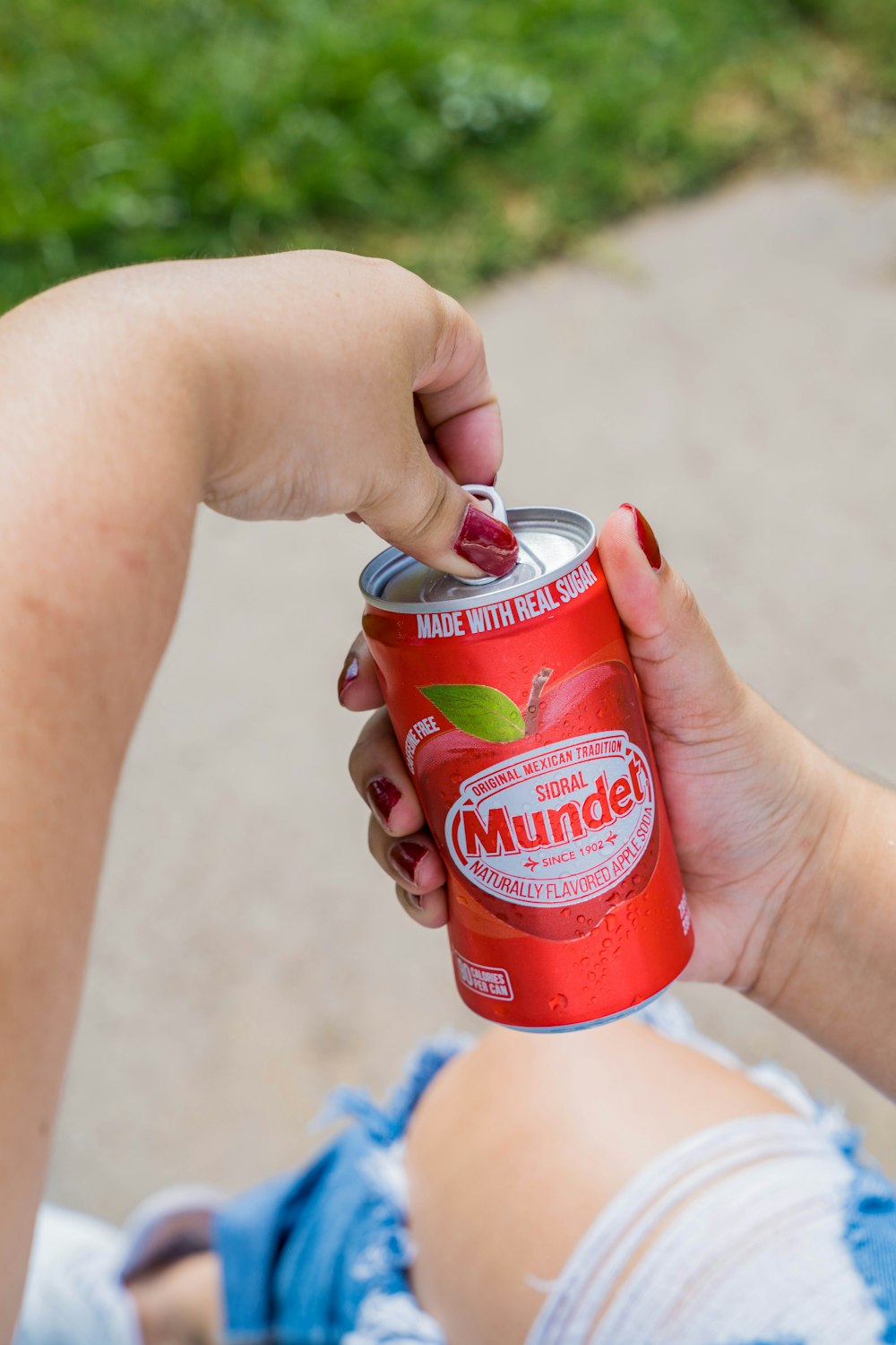 person holding red and white can