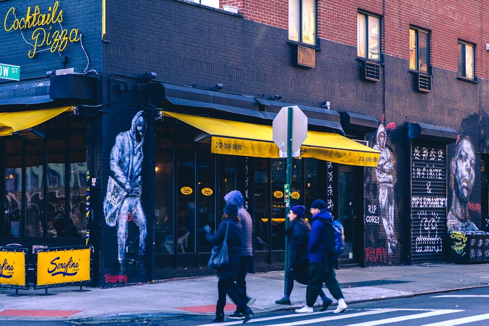 people walking on sidewalk near building during daytime