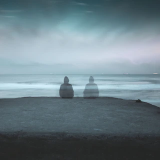 3 white and gray stone on black sand near body of water during daytime