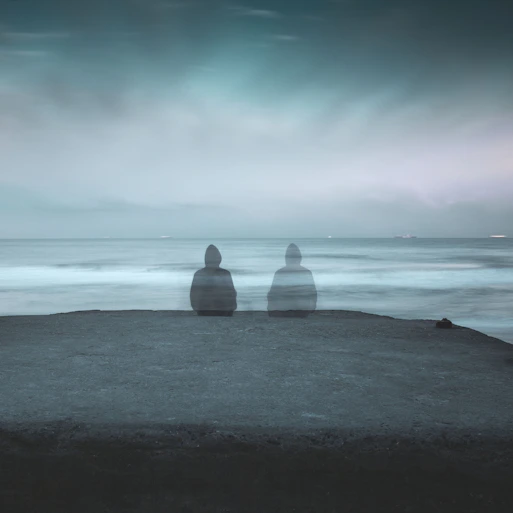 3 white and gray stone on black sand near body of water during daytime