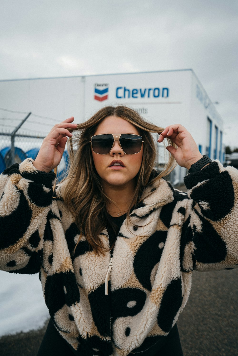 Mujer en abrigo de piel blanco y negro con gafas de sol