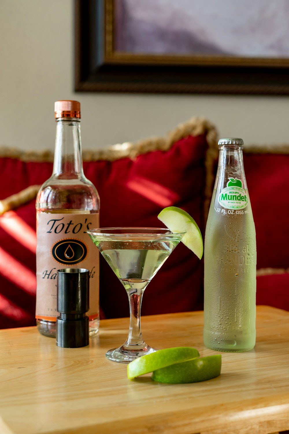 clear glass bottle beside clear drinking glass on green table