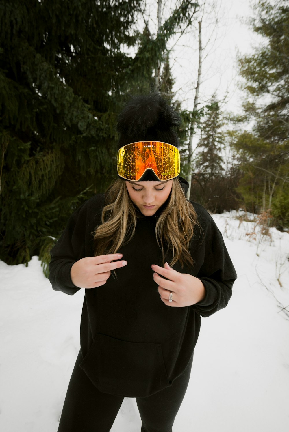 woman in black jacket covering her face with her hands