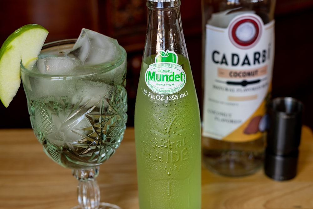 garrafa de vidro verde ao lado da tigela de vidro transparente