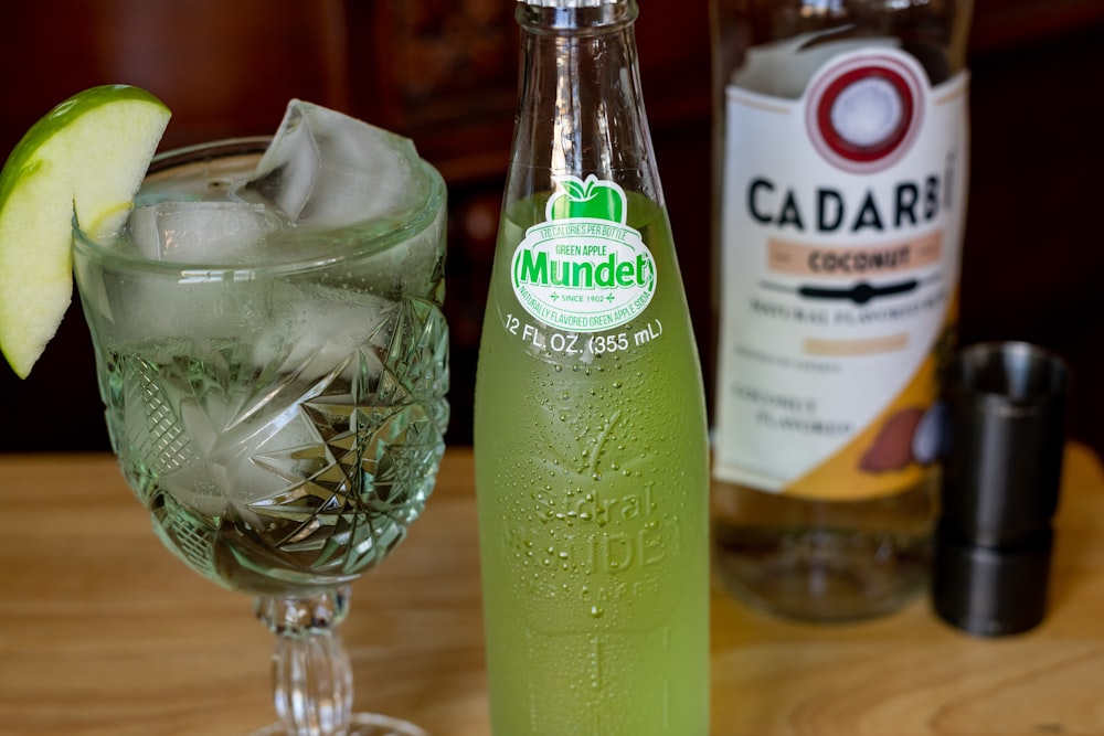 green glass bottle beside clear glass bowl