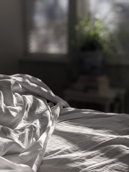 white textile on brown wooden bed frame
